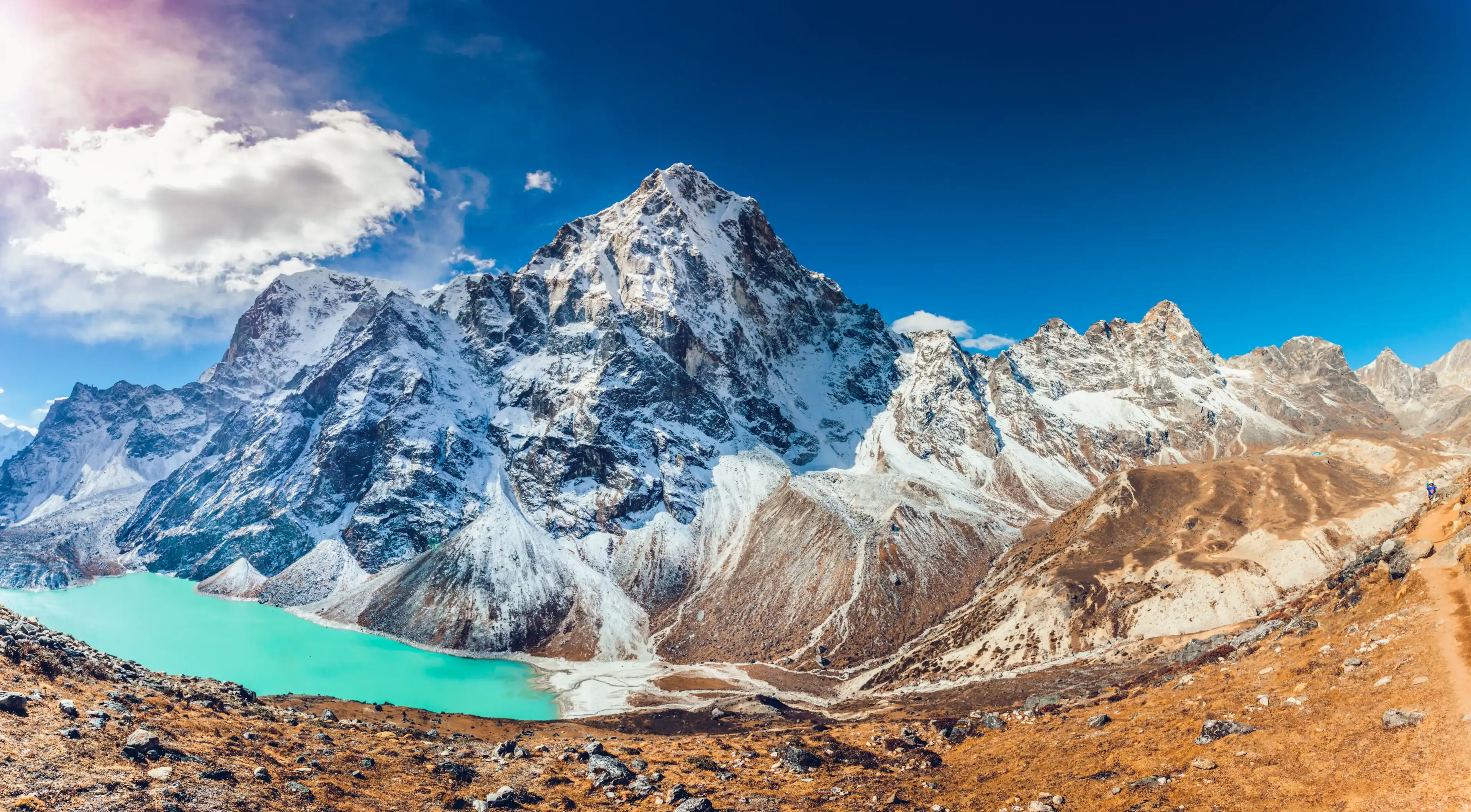 Valley of Himalayan mountains with mountain lake on track to Everest base camp. High mountains with snow-capped peaks. Khumbu valley, Sagarmatha national park, Nepal. Beautiful mountain landscape. Valley of Himalayan mountains with mountain lake on track to Everest base camp. High mountains with snow-capped peaks. Khumbu valley, Sagarmatha national park, Nepal. Beautiful mountain landscape.