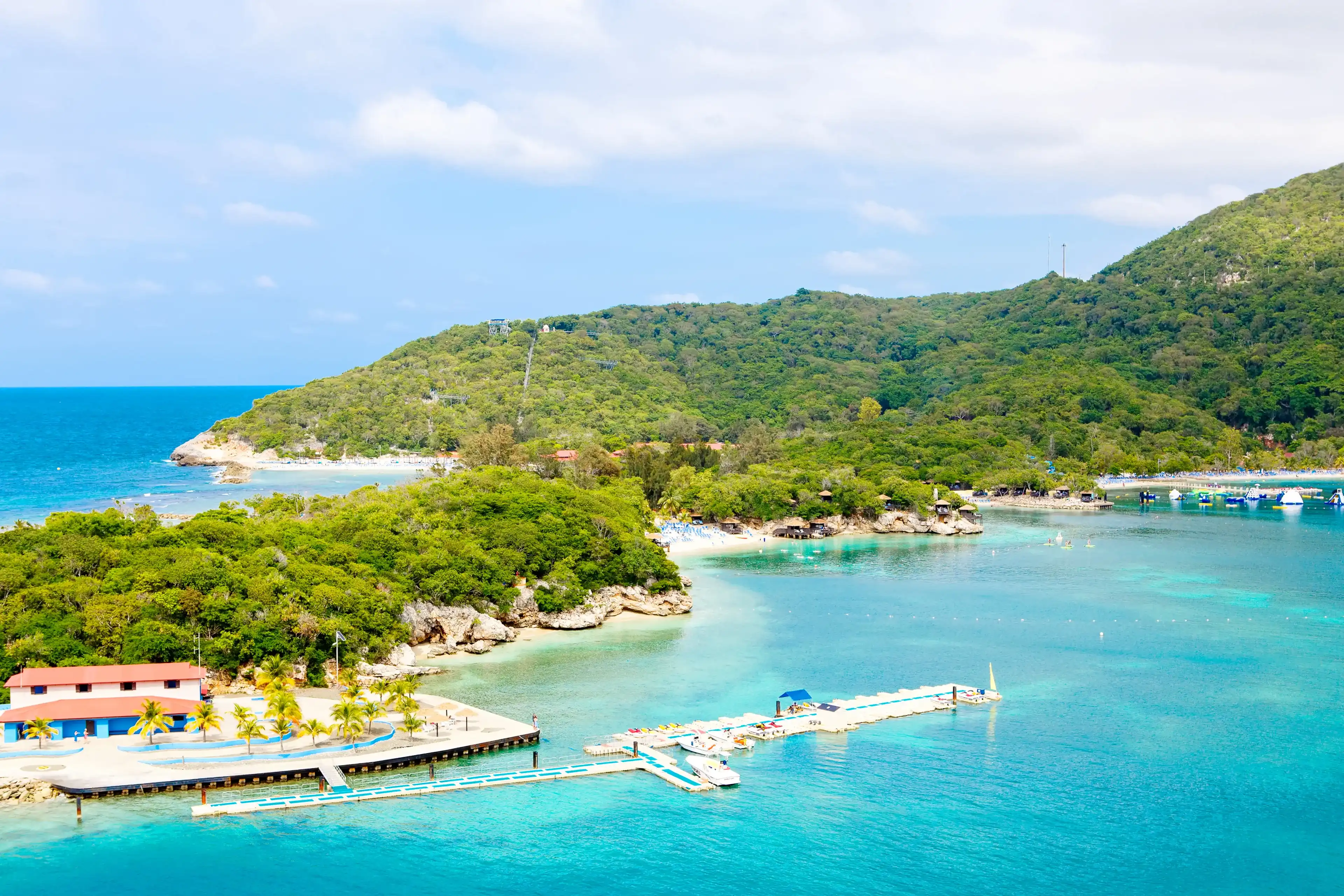 Beach and tropical resort, Labadee island, Haiti. Exotic wild beach with palm and coconut trees against blue sky and azure water Beach and tropical resort, Labadee island, Haiti. Exotic wild beach with palm and coconut trees against blue sky and azure water