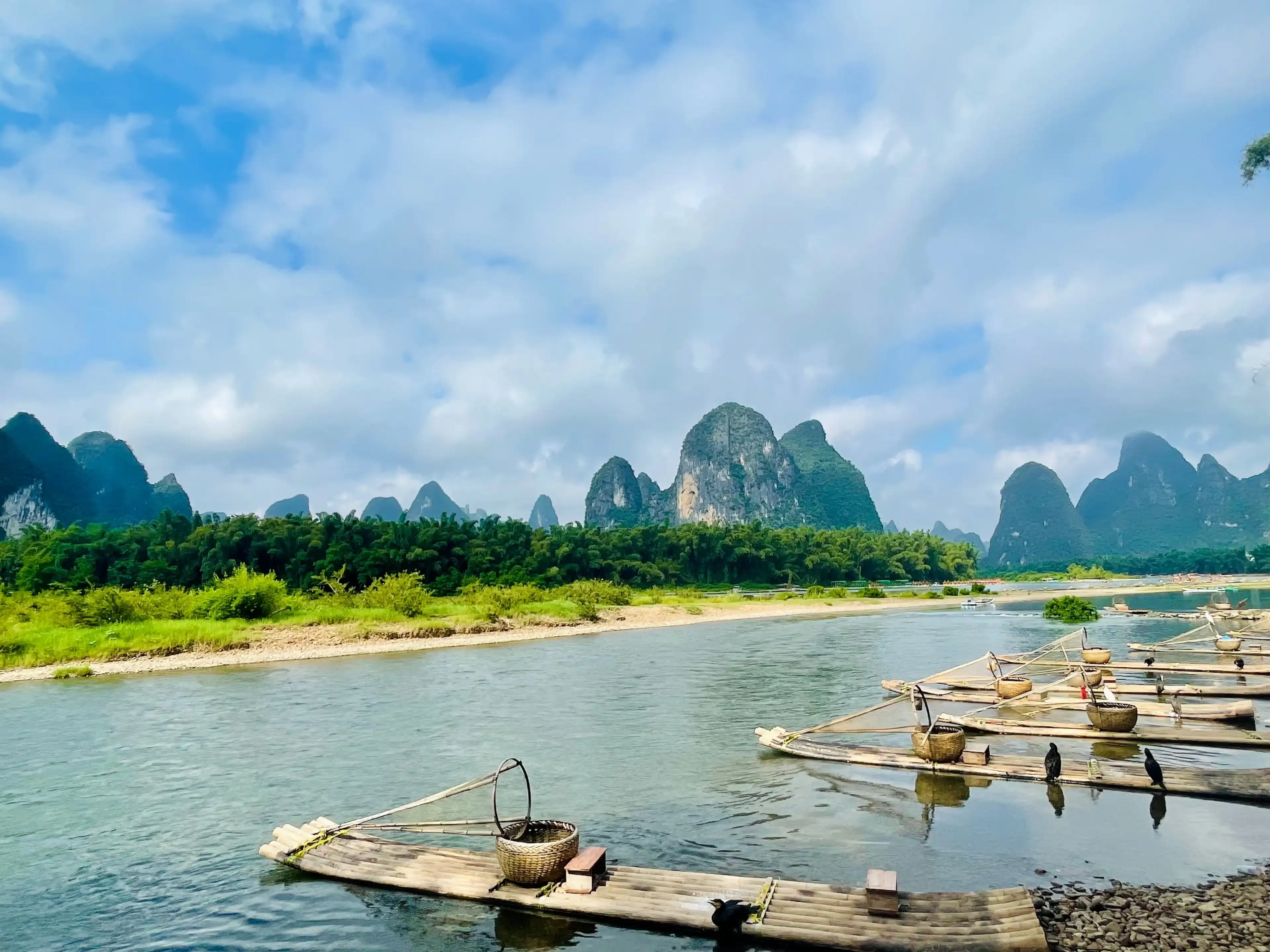 Traditional wooden boats on a tranquil river surrounded by karst mountains. Yangshuo, China Traditional wooden boats on a tranquil river surrounded by karst mountains. Yangshuo, China