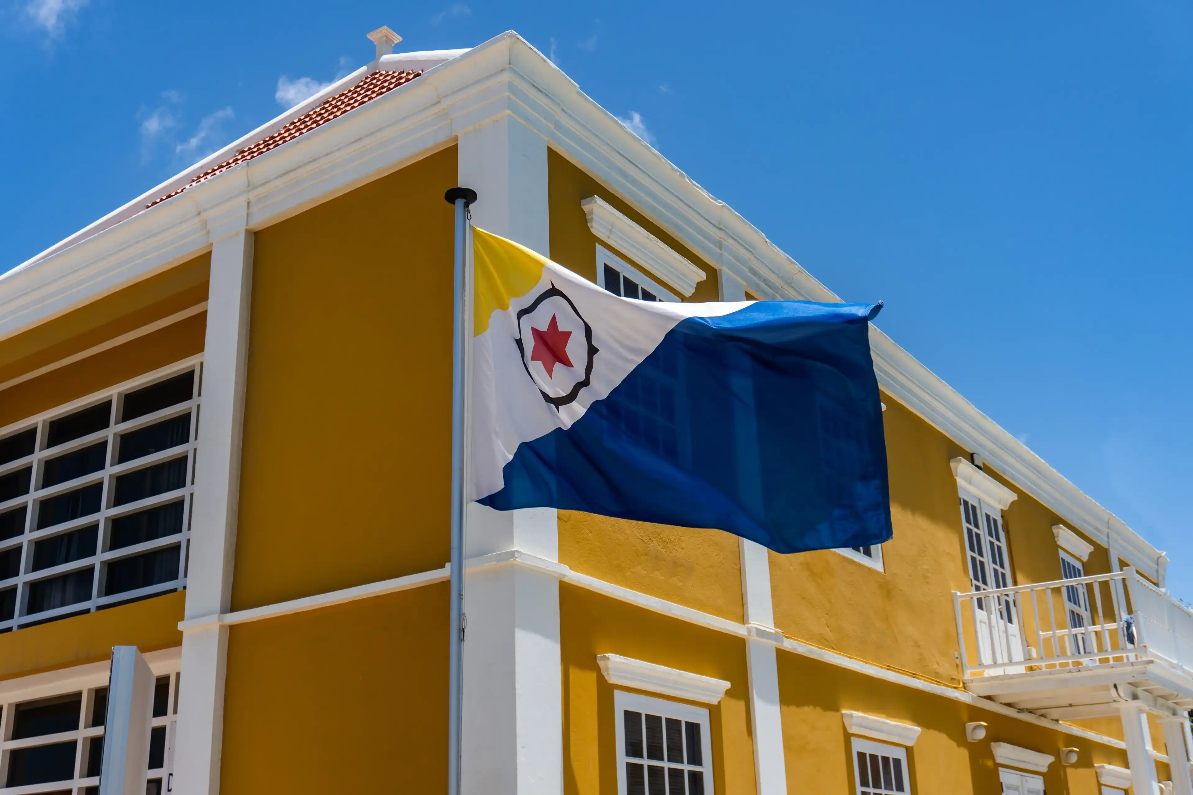 Kralendijk, Bonaire, Caribbean Netherlands: Douanekantoor - Customs Office and flag of Bonaire. Black compass, red six-pointed star, dark blue and yellow triangles. Kralendijk, Bonaire, Caribbean Netherlands: Douanekantoor - Customs Office and flag of Bonaire. Black compass, red six-pointed star, dark blue and yellow triangles.