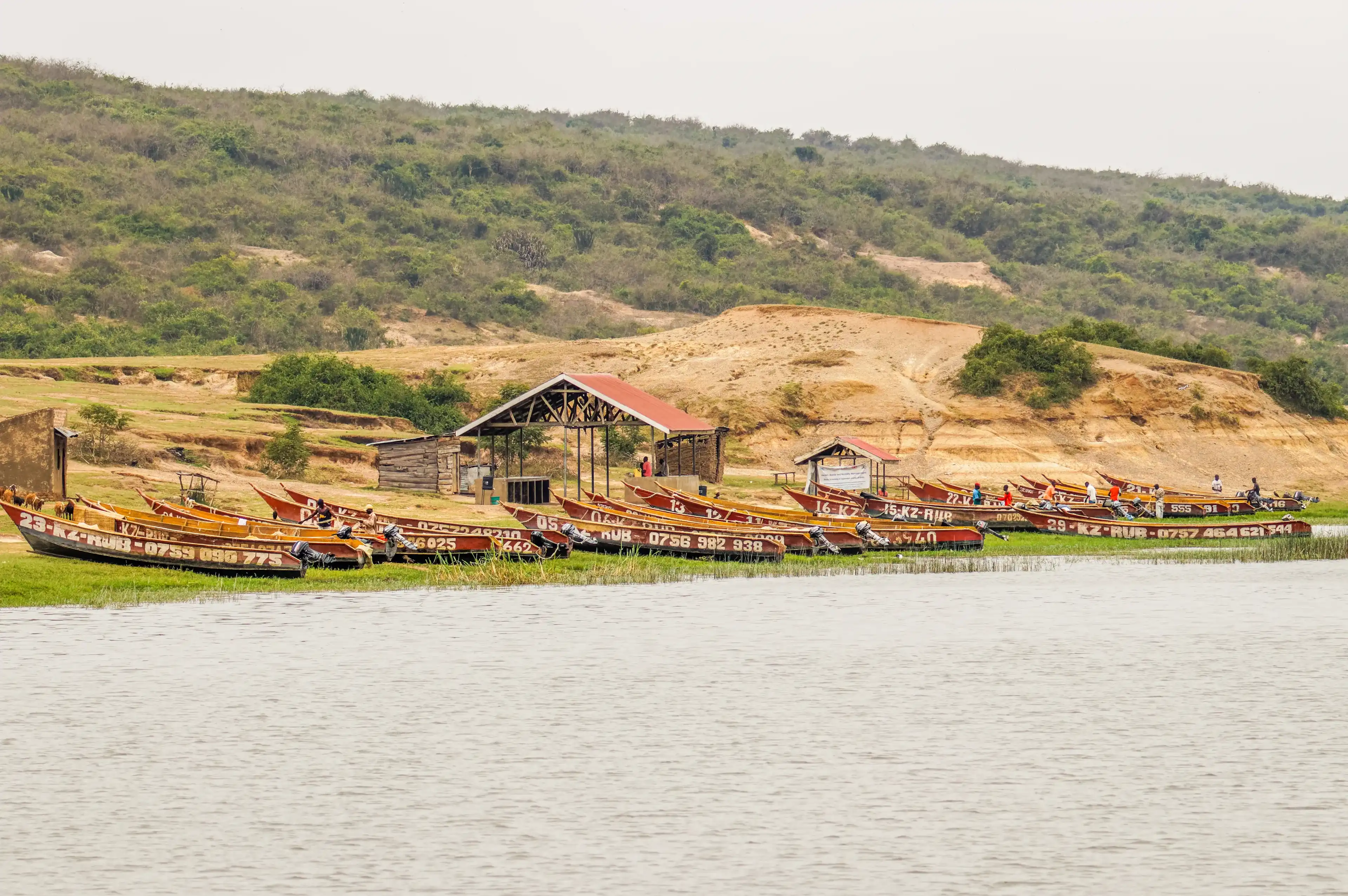 Kazinga Channel / Uganda - february 28 2020: Fishing boats shown on the Kazinga channel shore. The Kazinga channel is the only source of transportation in this region of central Africa. Kazinga Channel / Uganda - february 28 2020: Fishing boats shown on the Kazinga channel shore. The Kazinga channel is the only source of transportation in this region of central Africa.