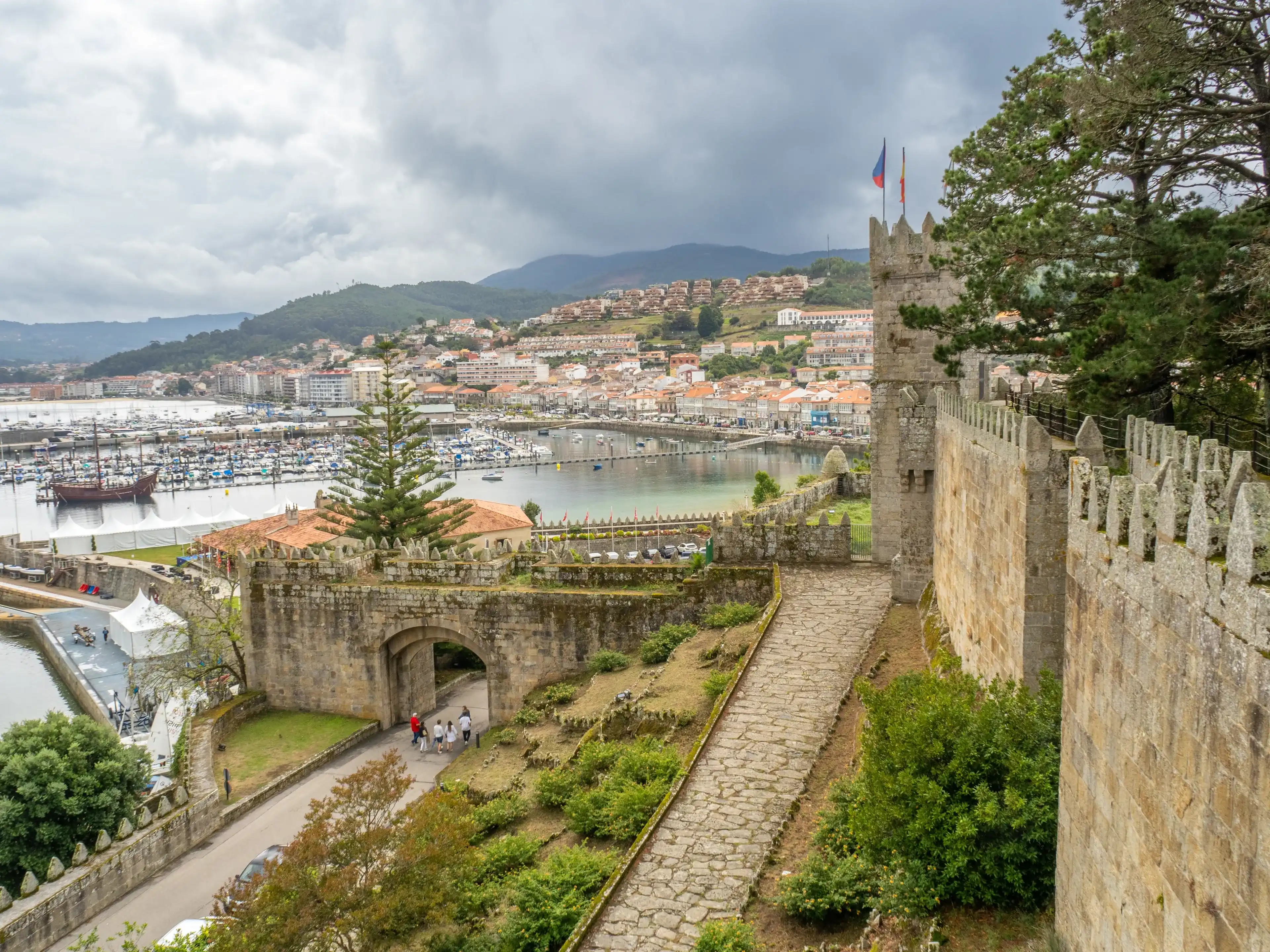 Breathtaking view of Baiona's port from Parador de Baiona, Pontevedra. Serene waters, charming boats, and historic architecture create a picturesque scene. Breathtaking view of Baiona's port from Parador de Baiona, Pontevedra. Serene waters, charming boats, and historic architecture create a picturesque scene.