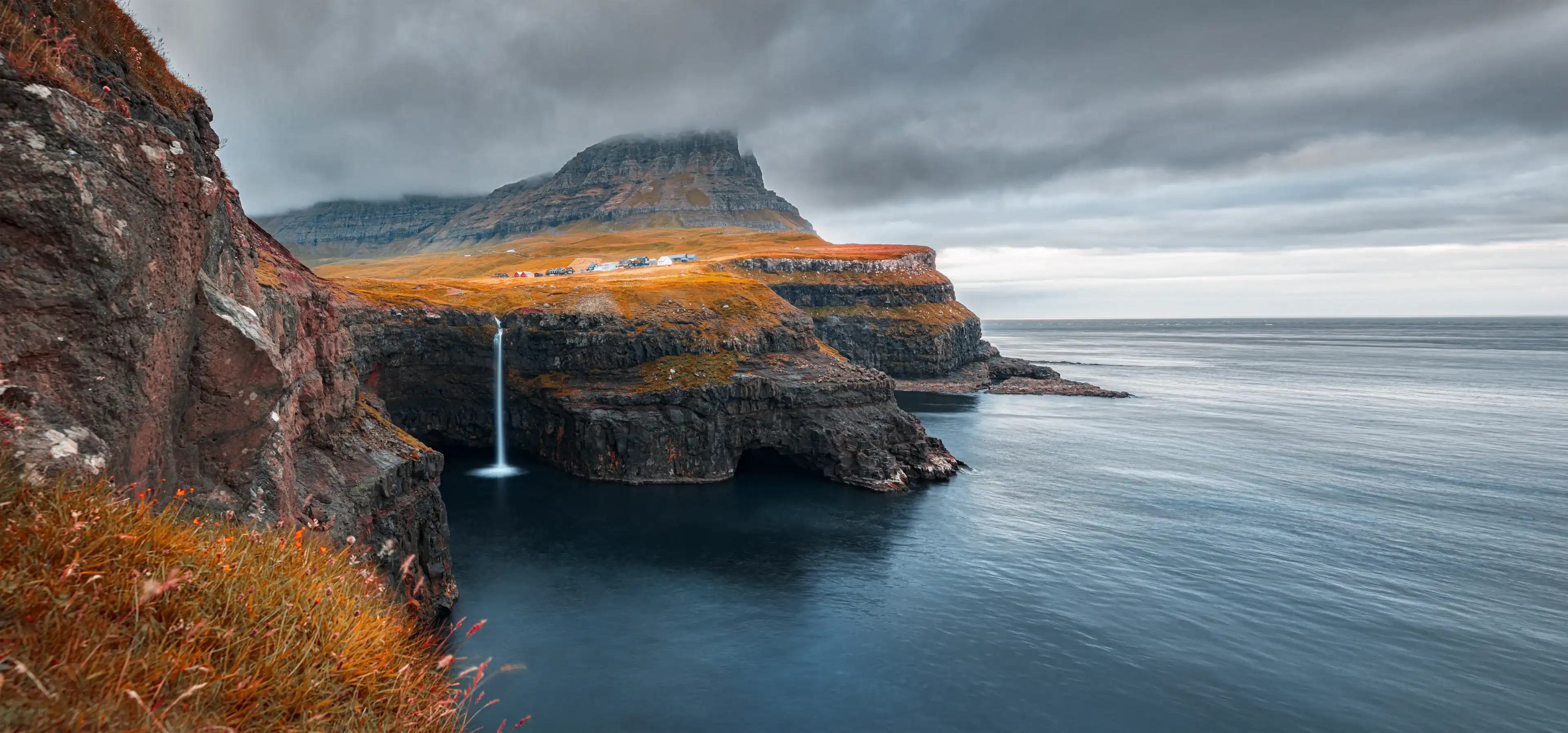 Incredible morning scene of Mulafossur Waterfall. Spectacular autumn view of Gasadalur village, Vagar, Faroe Islands, Denmark, Europe. Traveling concept background Incredible morning scene of Mulafossur Waterfall. Spectacular autumn view of Gasadalur village, Vagar, Faroe Islands, Denmark, Europe. Traveling concept background