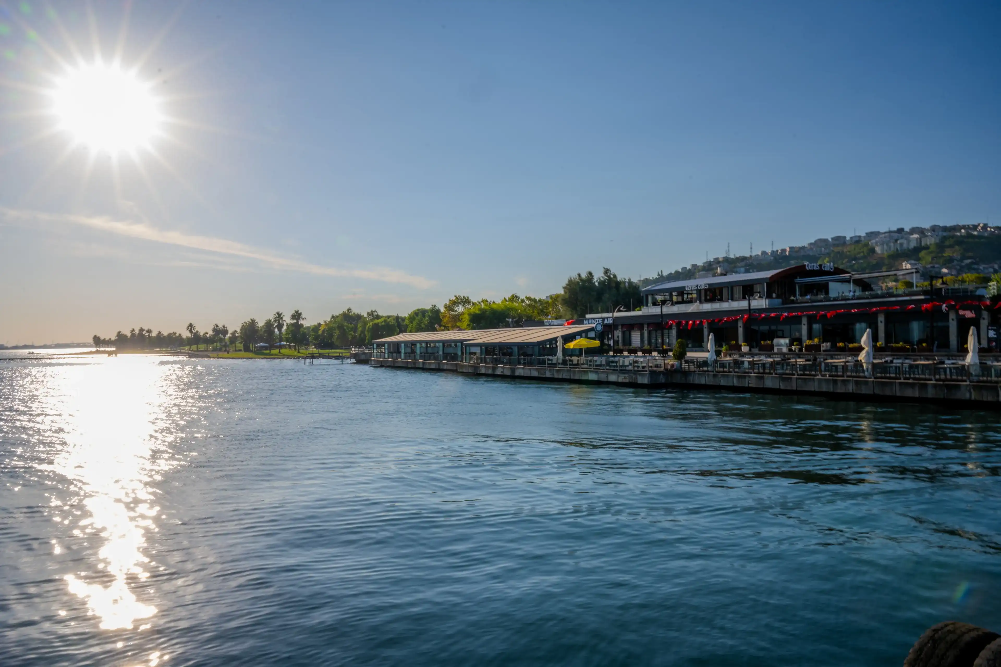 Sunlit Waterfront Cafes and Promenade Along the Shores of Sapanca Lake in Kartepe, Sakarya, Türkiye - August 29, 2023 Sunlit Waterfront Cafes and Promenade Along the Shores of Sapanca Lake in Kartepe, Sakarya, Türkiye - August 29, 2023