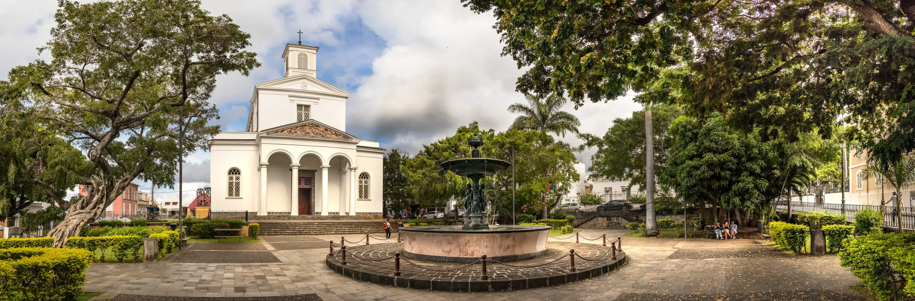 Saint Denis, Reunion Island - January 26th, 2019: Panoramic view of the St Denis Cathedral located next the Cathedral Fountain., Reunion Island. Saint Denis, Reunion Island - January 26th, 2019: Panoramic view of the St Denis Cathedral located next the Cathedral Fountain., Reunion Island.