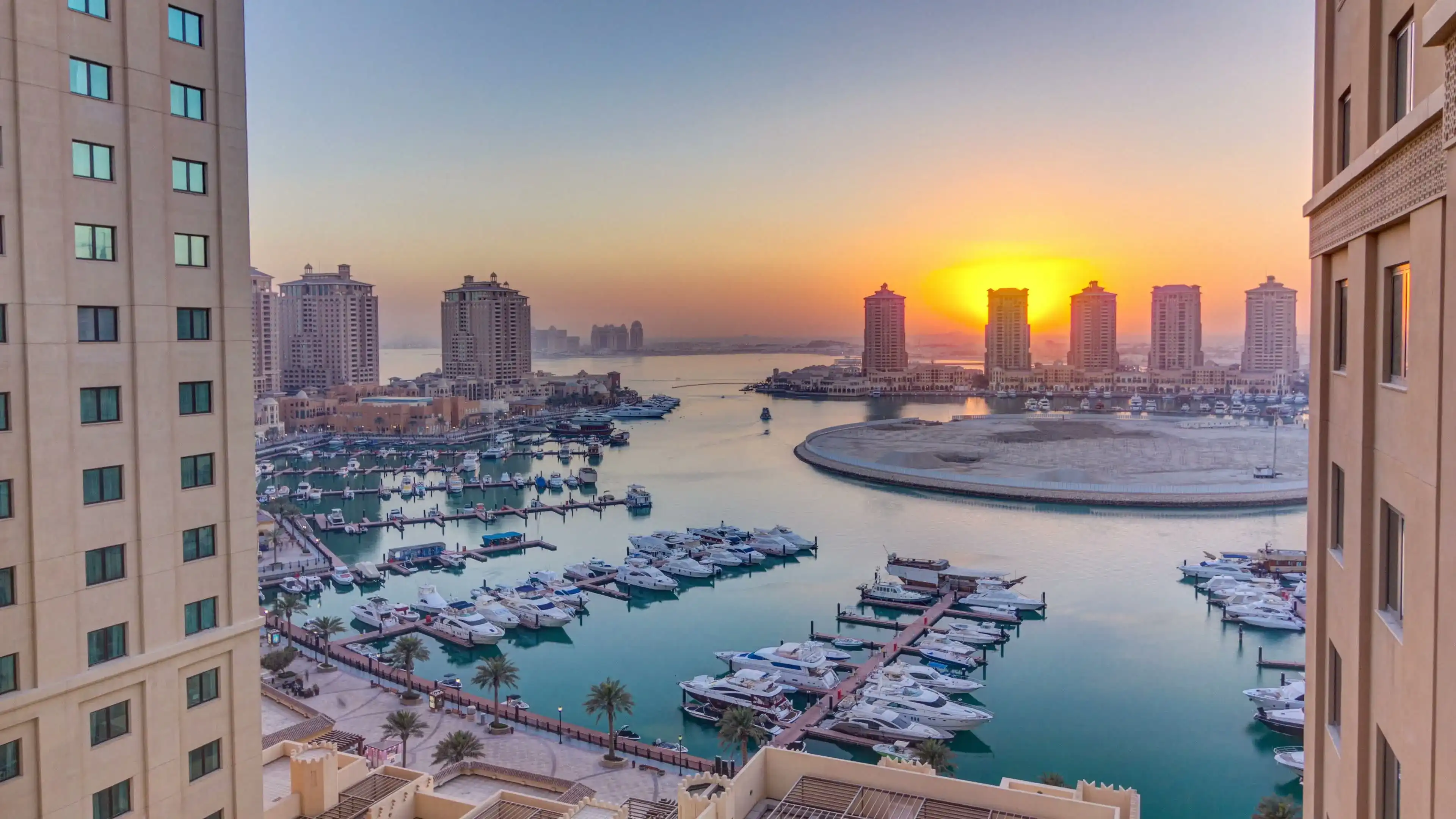 Sunset at the Pearl-Qatar timelapse from top. It is an artificial island in Qatar. View of the Marina and residential buildings in Porto Arabia in Doha, Qatar, Middle East Sunset at the Pearl-Qatar timelapse from top. It is an artificial island in Qatar. View of the Marina and residential buildings in Porto Arabia in Doha, Qatar, Middle East